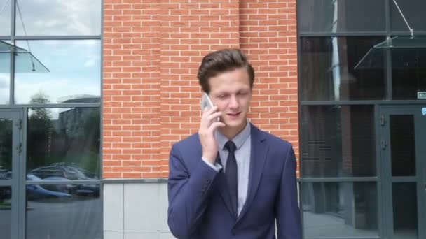 Feliz éxito caminando hombre de negocios hablando por teléfono, al aire libre — Vídeo de stock