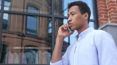 Genç siyah adam, yan görünüm açık telefon konuşma