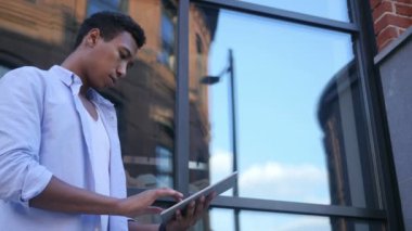 Meşgul çevrimiçi Tablet üzerinde çalışıyorsanız, ayakta genç erkek Tasarımcısı siyah