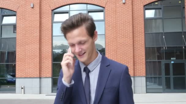 Щасливий ходьба молодий бізнесмен розмовляє по телефону, на відкритому повітрі — стокове відео