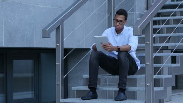 Navegando no Tablet PC enquanto Jovem Preto Sentado em Escadas — Vídeo de Stock