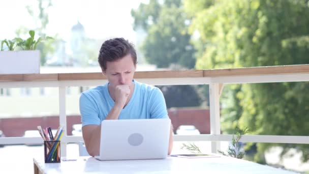 Кашель Молодий чоловік на роботі, сидячи на відкритому повітрі — стокове відео