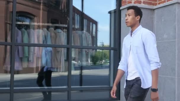 Счастливый молодой чернокожий человек гуляет на улице — стоковое видео