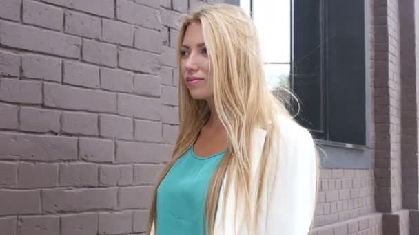 Blond meisje lopen buiten kantoorgebouw — Stockvideo
