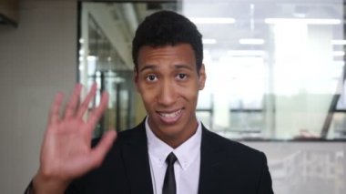 Merhaba, ofiste takım elbiseyle siyah işadamı tarafından el sallayarak