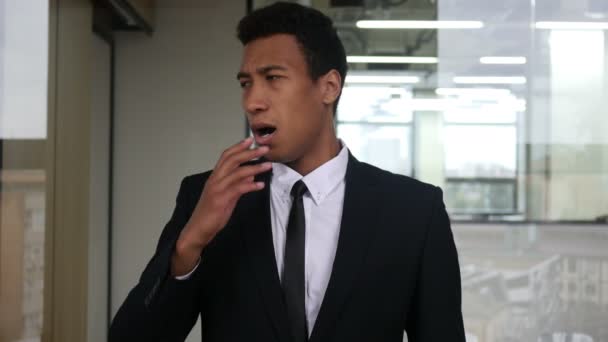 Empresario negro cansado bostezando en traje, interior — Vídeos de Stock