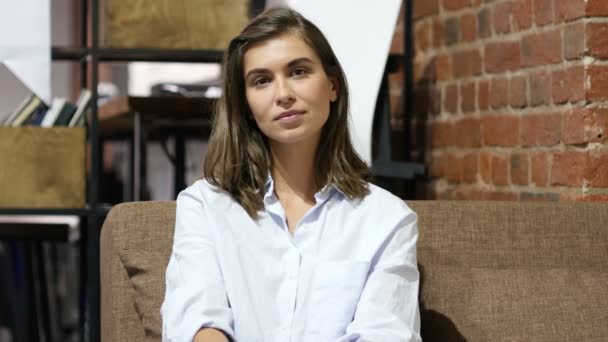 Chica sentada en el trabajo, mirando en la cámara — Vídeos de Stock