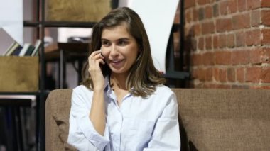 Telefon görüşmesi, koltukta oturan genç güzel kız tarafından müzakere