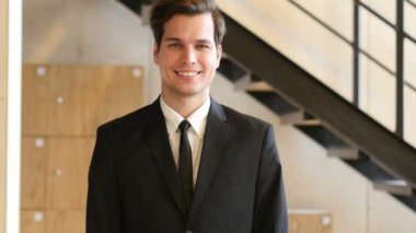 Takım elbiseli genç adam gülümsüyor