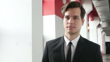 Office koridorda takım elbiseli genç adam yürüme