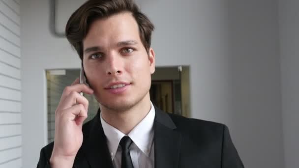 Uomo d'affari che cammina e parla al telefono in ufficio, Primo piano — Video Stock