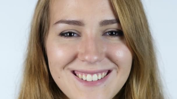 Крупним планом Обличчя красивої білої дівчини Усміхаючись, білий фон — стокове відео