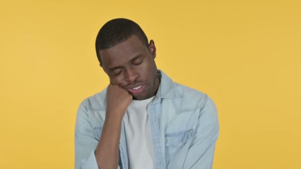 Slaperige jonge Afrikaanse man nemen van dutje, gele achtergrond — Stockvideo
