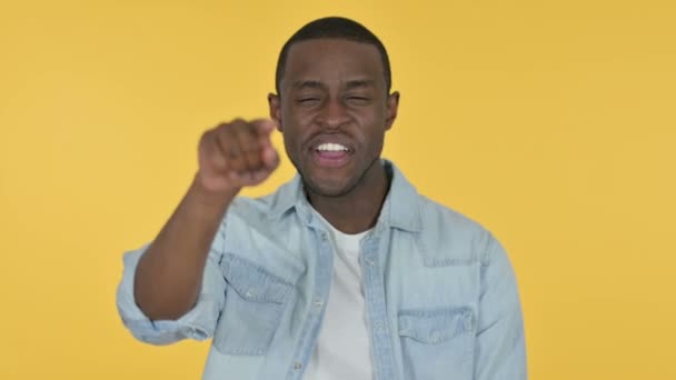 Jeune homme africain pointant du doigt et invitant, fond jaune — Video