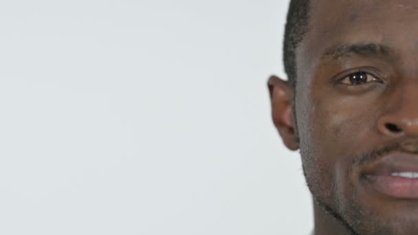 Hälften ansikte ung afrikansk man, vit bakgrund — Stockvideo