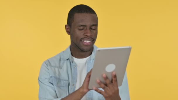 Joven africano usando tableta digital, fondo amarillo — Vídeos de Stock