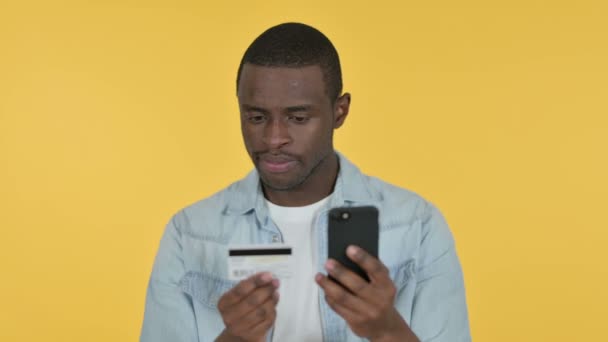 Compras Online no Smartphone por Jovem Africano, Fundo Amarelo — Vídeo de Stock