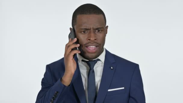 Uomo d'affari africano arrabbiato che parla su smartphone, sfondo bianco — Video Stock