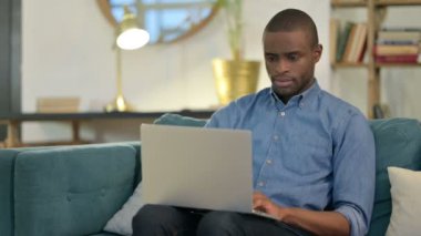 Genç Afrikalı Adam dizüstü bilgisayarını kapatıyor. 