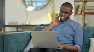 Dizüstü bilgisayar: Genç Afrikalı, Kanepede Boyun Ağrısı Olan Adam 