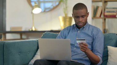 Kanepede Genç Afrikalı Adam tarafından Dizüstü bilgisayarda Alışveriş Başarısızlığı