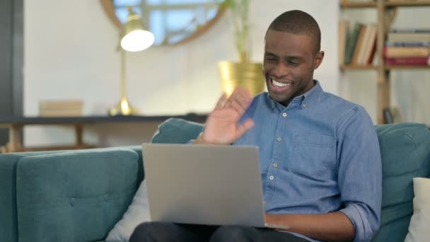 Online Video Call on Laptop by Young African Man on Sofa — Αρχείο Βίντεο