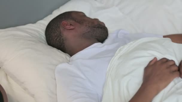 Irrequieto giovane africano cercando di dormire a letto — Video Stock