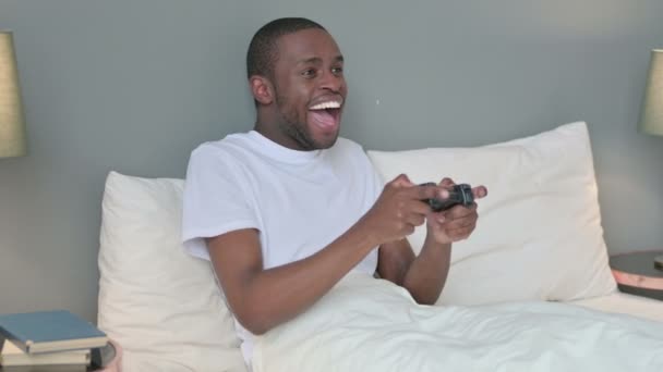 Eccitato giovane africano giocare video gioco a letto — Video Stock