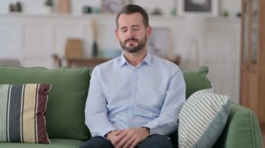 Yorgun genç adam uyuyor, koltukta oturuyor. 