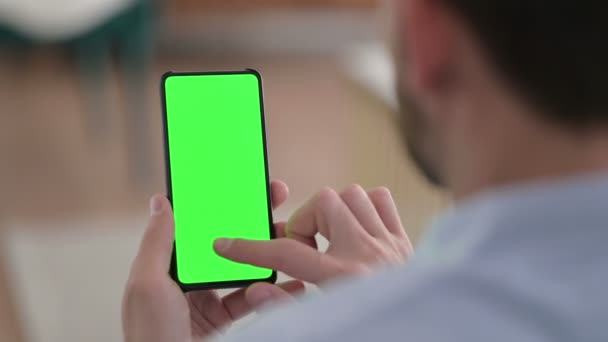 Hombre joven usando Smartphone con pantalla de croma verde — Vídeo de stock