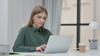 Dizüstü bilgisayarlı genç bir kadın Kameraya gülümsüyor 