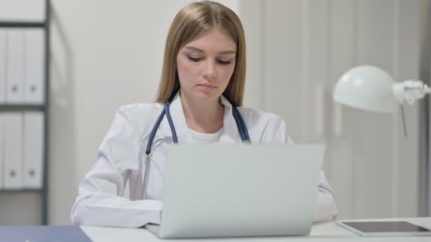 Молода жінка-лікар, що працює на ноутбуці — стокове відео
