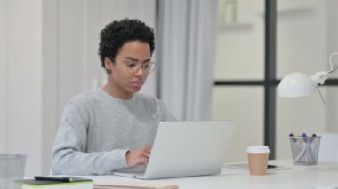 Ofiste dizüstü bilgisayarda çalışan genç Afrikalı kadın. 