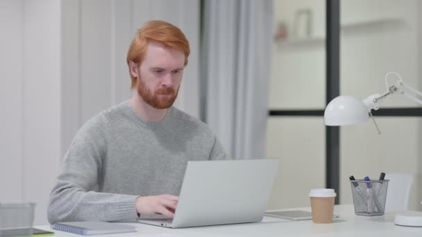 仕事で看板なしとしてノートパソコンの揺れ頭を持つ赤毛の男 — ストック動画