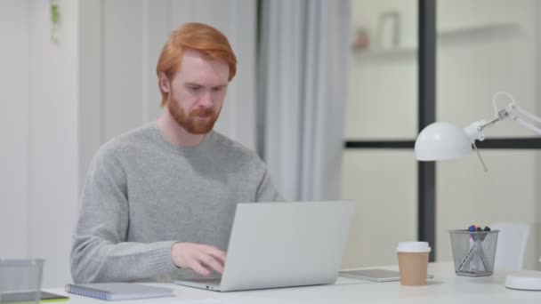 Rotschopf-Mann hat Rückenschmerzen beim Tippen auf Laptop — Stockvideo