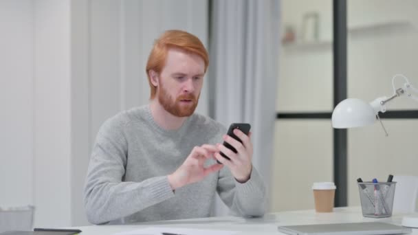 Redhead Man reagál veszteség használata közben Smartphone — Stock videók