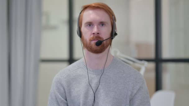 Portrait de jeune homme rousse portant un casque avec micro — Video