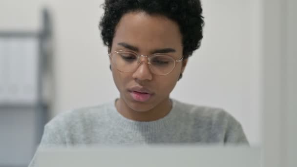Retrato de mujer africana con dolor de cabeza mientras usa el ordenador portátil — Vídeos de Stock