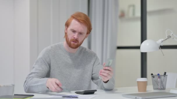 Redhead Man usando la calculadora mientras cuenta dólares — Vídeo de stock