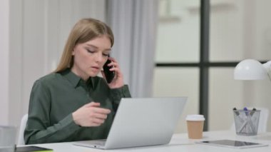 Laptop kullanırken Smartphone 'da Konuşan Genç Kadın 