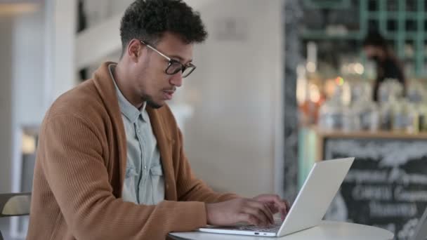 Uomo africano che lavora sul computer portatile in Cafe — Video Stock