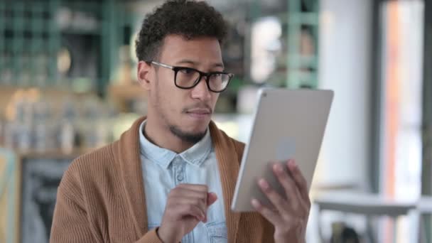 Hombre africano celebrando el éxito en la tableta — Vídeos de Stock