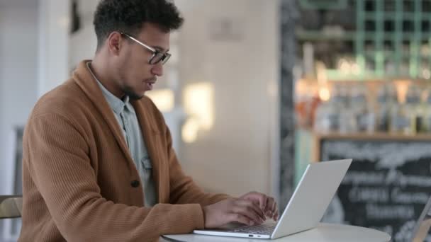 Afrikaner hustet, während er Laptop im Cafe benutzt — Stockvideo