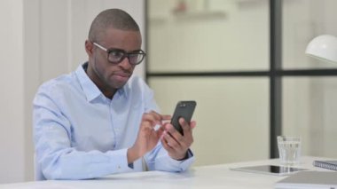 İş yerinde akıllı telefon kullanan Afrikalı adam 