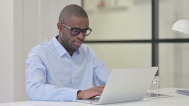 Kamerayı gösteren dizüstü bilgisayarı olan Afrikalı adam. 