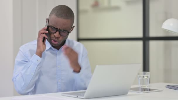 Irritado Africano Homem falando no telefone no trabalho, gritando — Vídeo de Stock