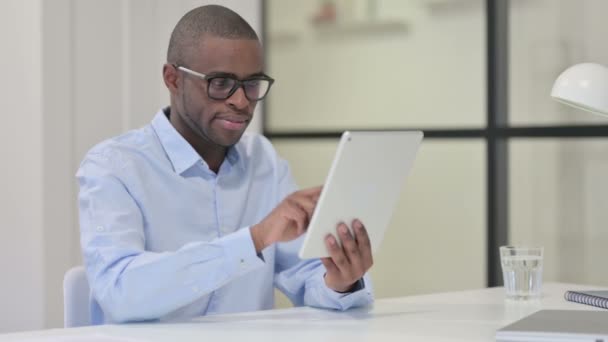 Exitoso hombre africano celebrando en la tableta en el trabajo — Vídeo de stock