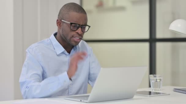 Африканський чоловік, що переніс біль, коли друкував на ноутбуці — стокове відео