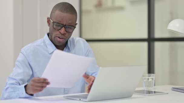 Enojado hombre africano molesto después de leer documentos en el trabajo — Vídeo de stock