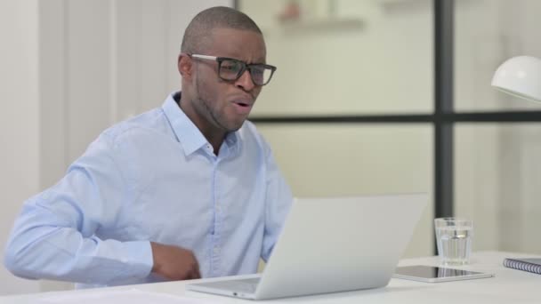 Africain ayant mal au dos tout en tapant sur ordinateur portable — Video